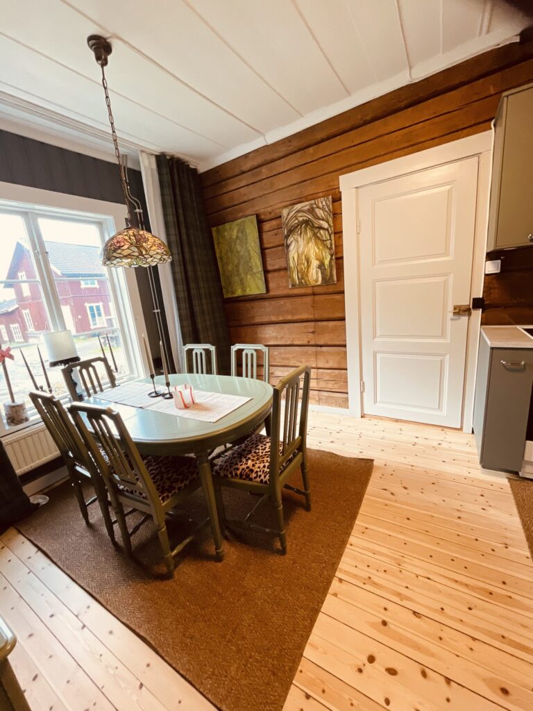 Matbord vid fönstret mot en timrad vägg