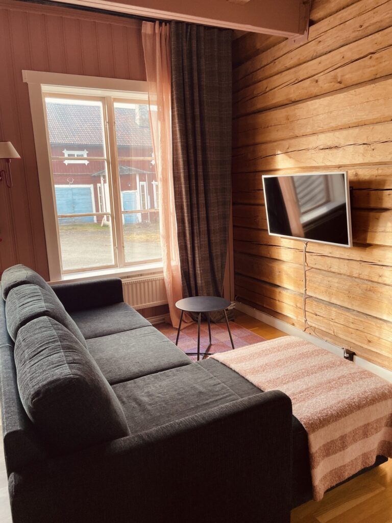 Soffa och tv vid en timrad vägg